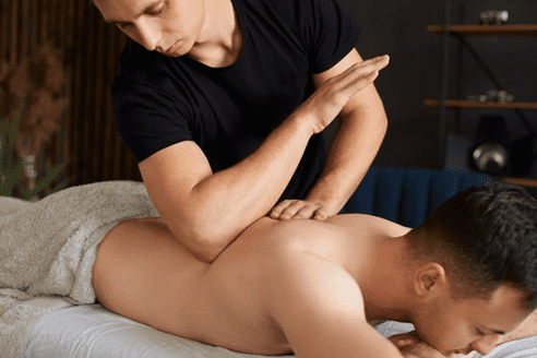 ماساژور در حال اجرای ماساژ درمانی با تمرکز بر کاهش درد عضلانی